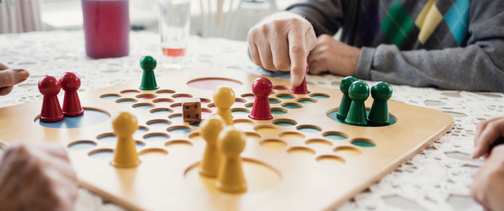 Ältere Menschen spielen eine Partie Mensch-ärgere-dich-nicht