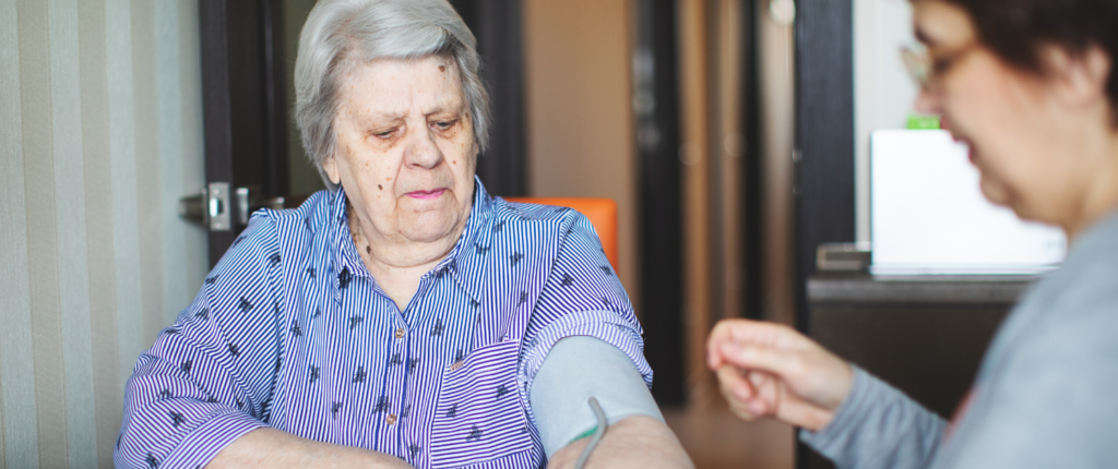 Eine ältere Frau wird in ihrer häuslichen Umgebung versorgt