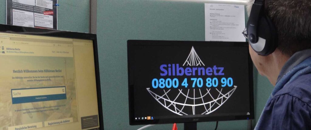 Ein Mann sitzt vor zwei Bildschirmen