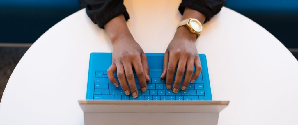 Hände, die auf der Tastatur eines Laptops liegen