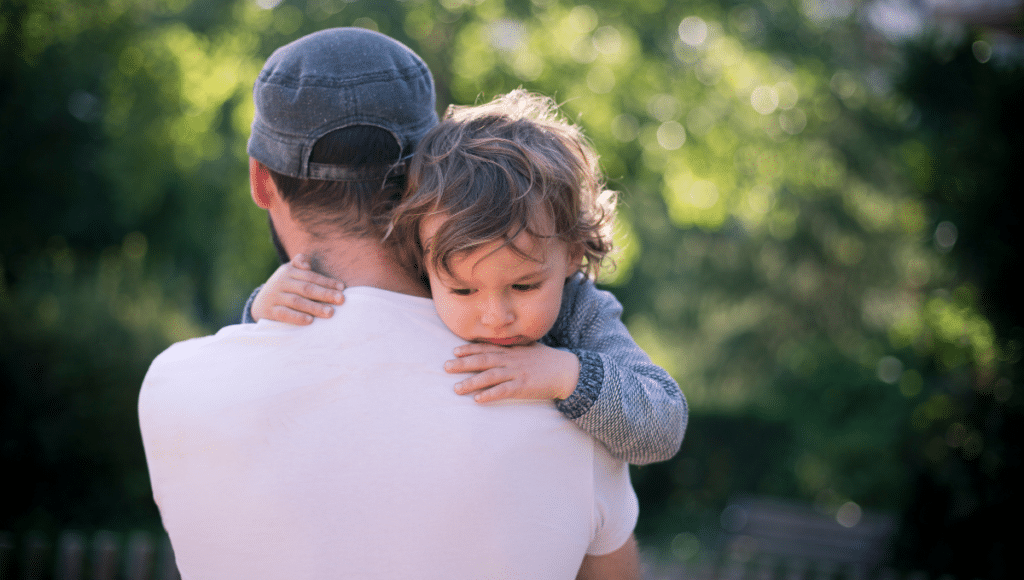 Pflegebedürftige Kinder: Ein Vater trägt ein kleines Kind auf dem Arm.