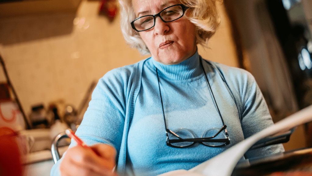 Eine Frau schreibt in ein Pflegetagebuch.